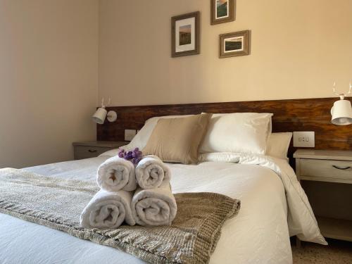 a bedroom with a bed with towels on it at Fonda Peremiquel in Castellar de NʼHug