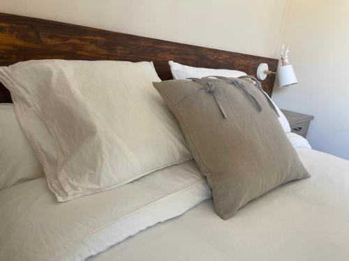a bed with white pillows and a wooden headboard at Fonda Peremiquel in Castellar de NʼHug