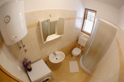 ein Bad mit einem WC, einem Waschbecken und einer Dusche in der Unterkunft Apartments Vedrana in Zadar