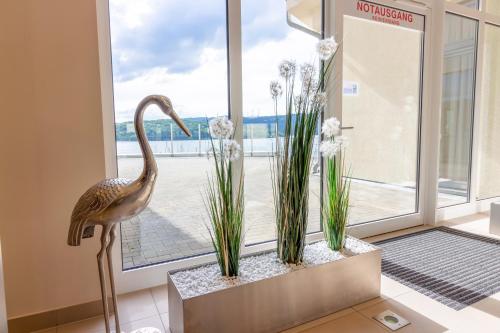a statue of a bird in a room with a window at Der Seehof in Heimbach