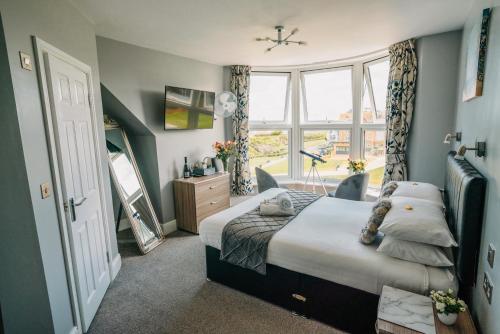 a bedroom with a bed and a large window at OYO Minerva Guesthouse in Newquay