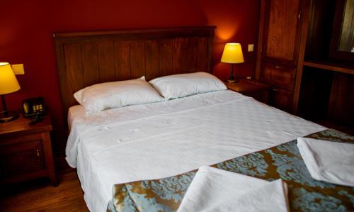 a large bed in a red room with two lamps at Dores Residence in Turunc
