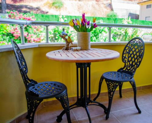 a table with two chairs and a table with flowers at Dores Residence in Turunc