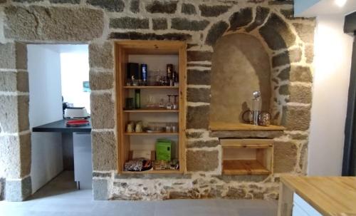 - une cuisine avec un mur en pierre et un meuble en bois dans l'établissement 15 Les Ours, à Plouër-sur-Rance