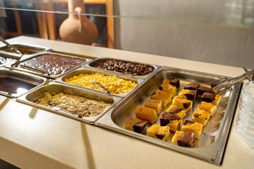 a buffet with several trays of food on a counter at Hotel Kathrin Beach in Adelianos Kampos
