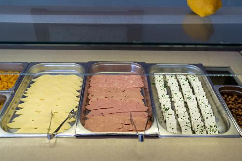 a tray of food with meats and cheese on a counter at Hotel Kathrin Beach in Adelianos Kampos