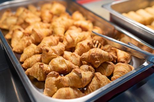 a bunch of donuts in a tray on a buffet at Hotel Kathrin Beach in Adelianos Kampos