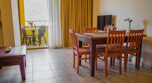 a dining room with a wooden table and chairs at Dores Residence in Turunc