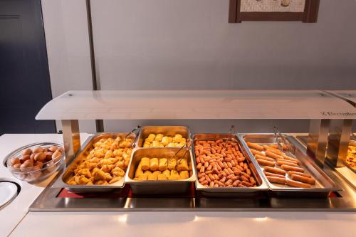 a buffet filled with trays of different types of food at Hotel Kathrin Beach in Adelianos Kampos