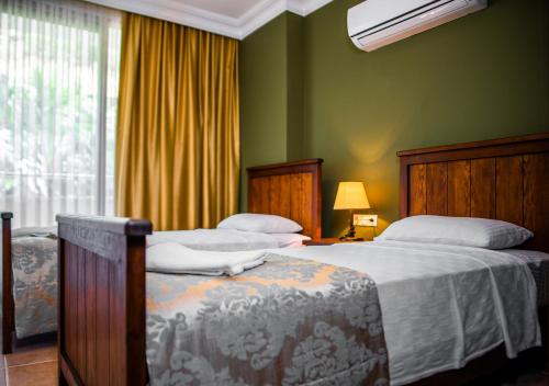 a bedroom with two beds and a window at Dores Residence in Turunc