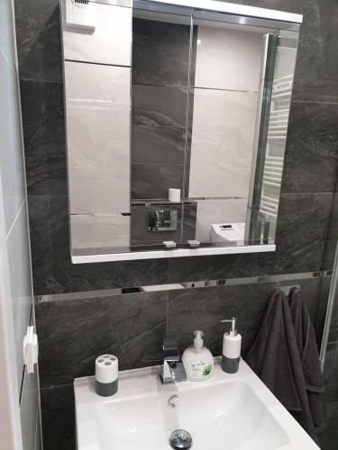 łazienka z umywalką i lustrem w obiekcie Apartament Słoneczny Taras w Kołobrzegu