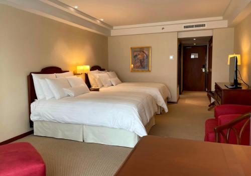 a hotel room with two beds and a television at Swissotel Lima in Lima