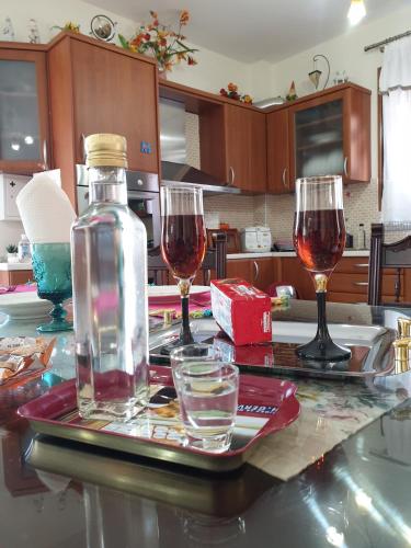 two glasses of wine and a bottle on a table at Triopetra Luxury Villas Fournou Lago in Triopetra