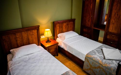 a bedroom with two beds and a lamp on a table at Dores Residence in Turunc
