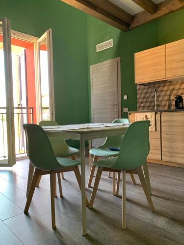 a dining room with a table and green chairs at Sala dell Estate Guest House in Secchia