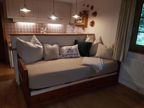 una cama con muchas almohadas en una habitación en Ferienhaus Erika, en Mallnitz