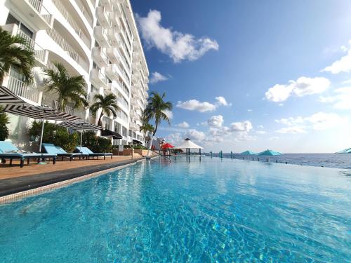 una grande piscina accanto a un edificio vicino all'oceano di Coral Princess Hotel & Dive Resort a Cozumel