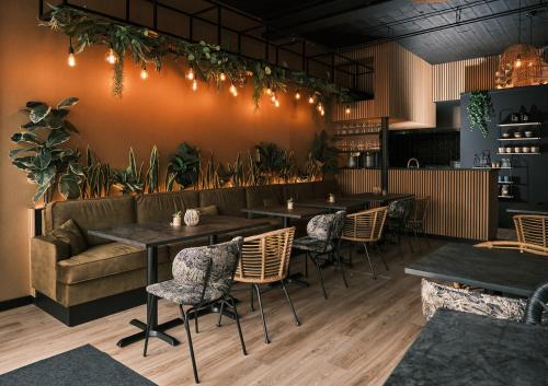 a restaurant with tables and chairs and a couch at Stadshotel Weert in Weert