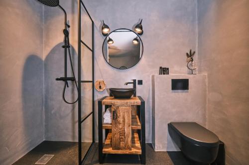 a bathroom with a black toilet and a mirror at Stadshotel Weert in Weert