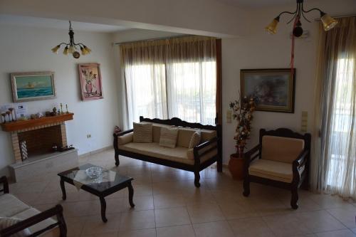 a living room with a couch and a chair at Triopetra Luxury Villas Fournou Lago in Triopetra