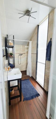 a bathroom with a sink and a shower with a ceiling fan at Domy na wodzie Charzykowy in Charzykowy