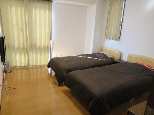Kasama的住宿－Monzen House Private room - Vacation STAY 49372v，一间卧室配有两张床和电视。