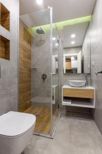 a bathroom with a shower and a toilet and a sink at Inter Holiday Apartments in Pomorie