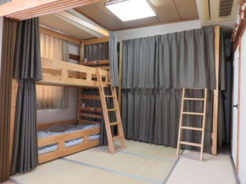 ein Schlafzimmer mit Etagenbetten und einer Leiter in der Unterkunft Monzen House Dormitory type- Vacation STAY 49374v in Kasama