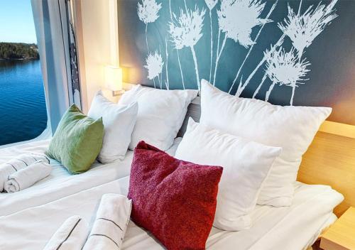 a white bed with pillows on it next to a window at Viking Line ferry Viking Grace - Mini-cruise from Turku in Turku