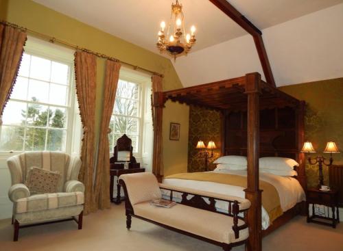 een slaapkamer met een hemelbed en een stoel bij Westgate Manor in Westgate