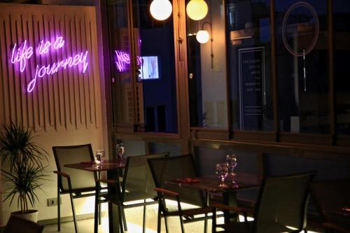 a restaurant with two tables and a neon sign at HOTEL BRONTE in Istanbul