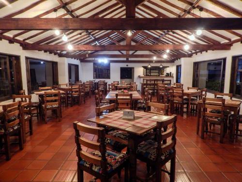 an empty restaurant with wooden tables and chairs at Hotel Mesón de los Virreyes in Villa de Leyva