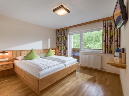Un dormitorio con una cama grande y una ventana en Appartementhaus Fuchs en Itter