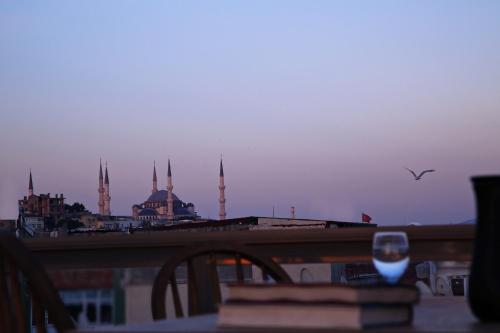 a wine glass sitting on a table with a view of a mosque at HOTEL BRONTE in Istanbul