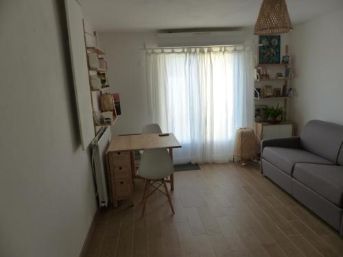 un salon avec un canapé et une table dans l'établissement Chambre privative près de l'étang de Thau, à Sète