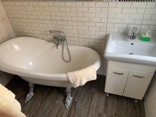 a white bath tub and a sink in a bathroom at Apartamenty Wikoli in Międzyzdroje