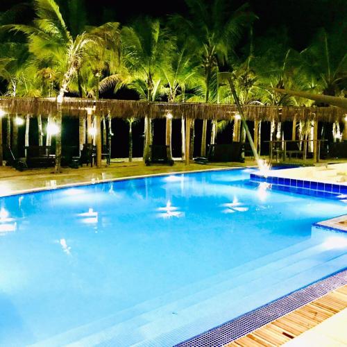 a large swimming pool at night with palm trees at ALIZE CUMBUCO in Cumbuco