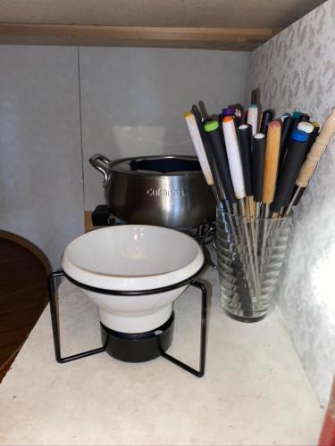 a counter with a pot and a bowl and chopsticks at Chalet "Ici et maintenant, sur le lac" in Sainte-Marguerite