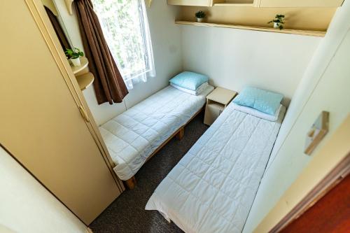 a small room with two beds and a window at Namelių nuoma Giruliuose in Klaipėda