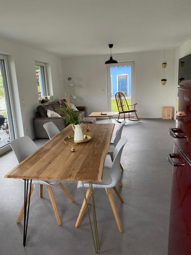 a living room with a wooden table and chairs at Villa Frankenstein - Deluxe Ferienwohnung mit Ladestation E-Auto & E-Bike in Lancken-Granitz