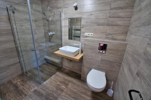 a bathroom with a shower and a toilet and a sink at Chata Panoráma Zuberec in Zuberec