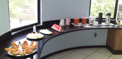 a table with plates of food on a counter at Jacarandá Palace Hotel in Teixeira de Freitas