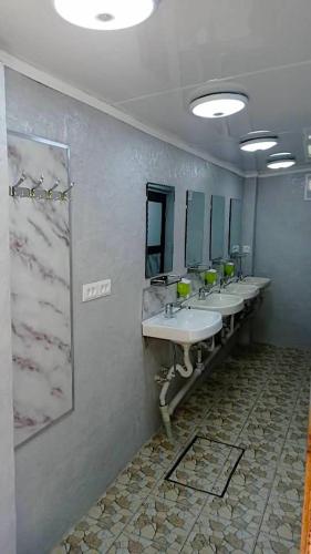 a bathroom with four sinks and a row of mirrors at Arista Yurt Camp in Karakol
