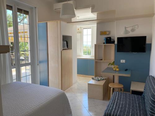 Dormitorio con cama, escritorio y TV en Residence Villa Ombrosa, en Spotorno