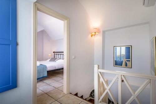 a room with a bed and a door leading to a bedroom at Golden Grey Goose in Fira