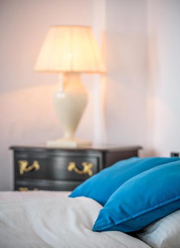 a bed with a table with a lamp on it at Golden Grey Goose in Fira