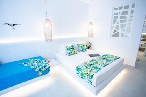 Cette chambre blanche comprend deux lits et un canapé. dans l'établissement Likio Studios, à Batsi
