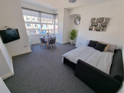 a bedroom with a bed and a table and a clock at Highview House Redcar-Seaview Apartments in Redcar