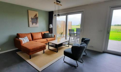 a living room with a couch and a table and chairs at Hof Babel in Domburg
