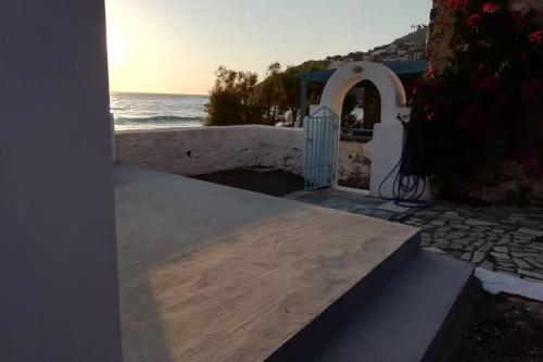 a door to a house with the ocean in the background at Paradise on Kantouni Beach-20m from Boutique Hotel in Kalymnos